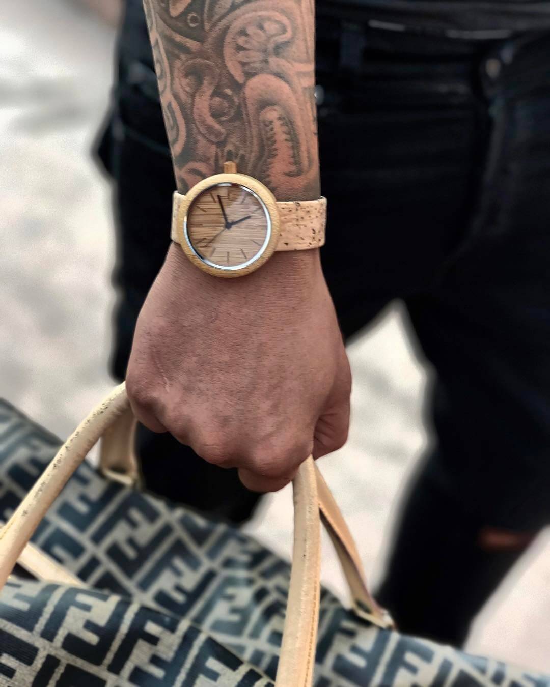 Handcrafted eco-friendly panda watch made from bamboo and cork, held on wrist with tattoo, showcasing minimalist design.