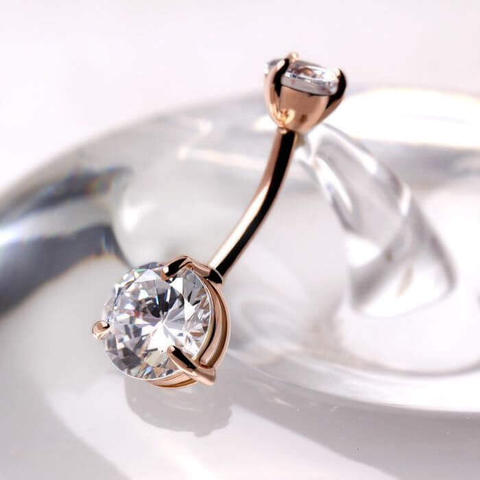 14Kt rose gold navel ring featuring clear round CZ, showcasing prong setting and elegant design.