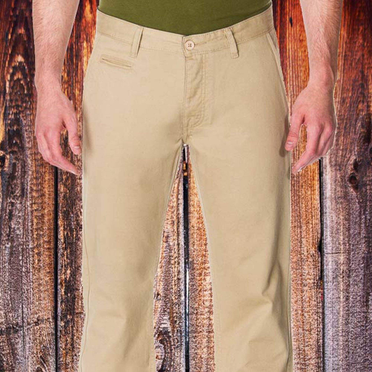 Men's khaki chino pants displayed on a model, showcasing a slim fit against a rustic wooden background.