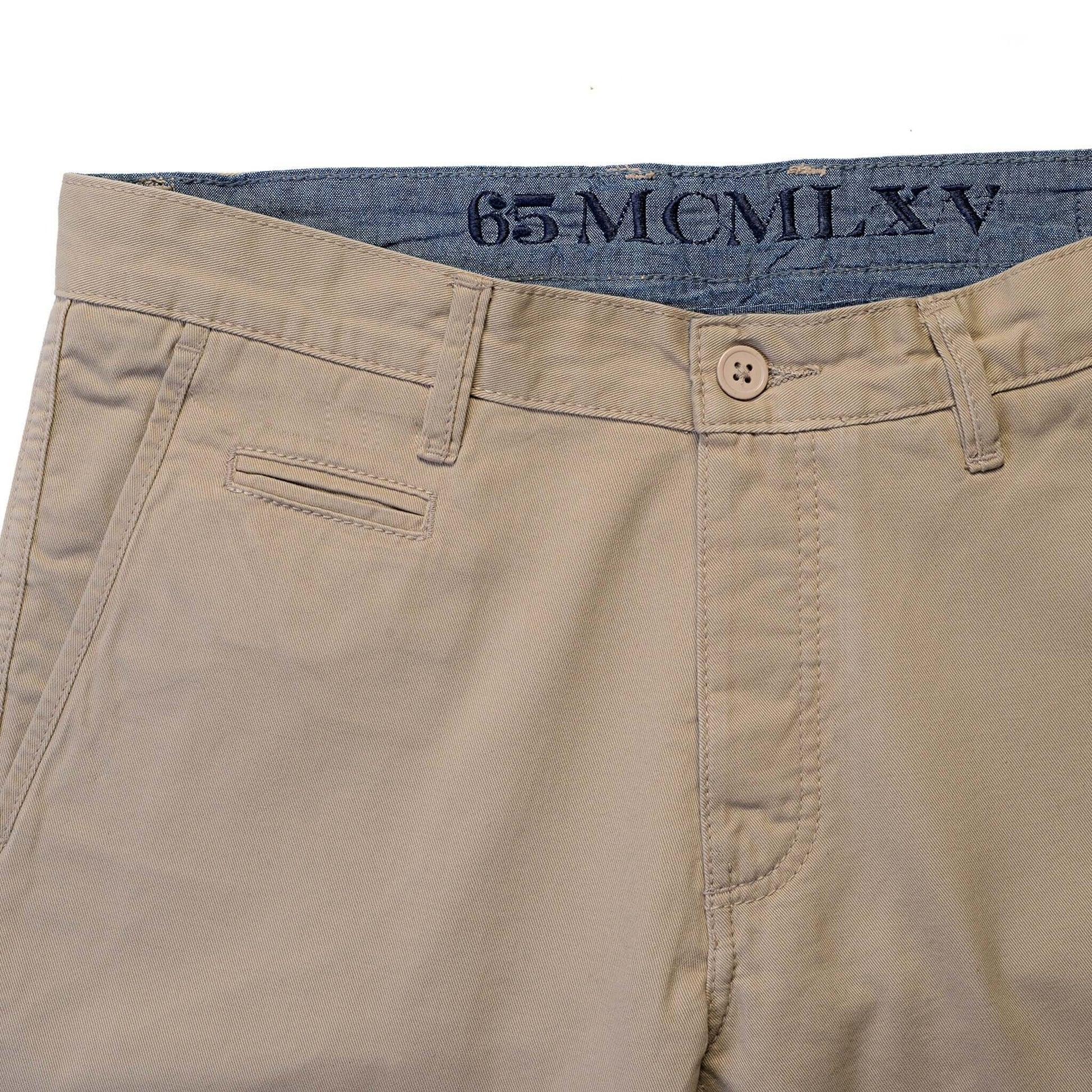 Close-up of 65 McMlxv men's khaki chino pant featuring slim fit design and button closure.