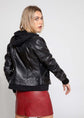 Back view of Annalise Womens Leather Jacket featuring fleece hoodie, black lambskin leather, and a stylish red skirt.